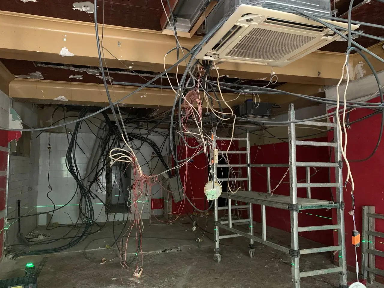 O espaço do café antes da obra: teto aberto, cablagem exposta, andaime