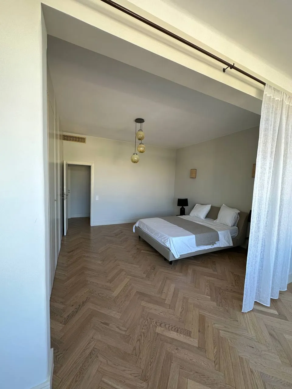 Quarto com zona de vestir separada por cortina de tecido do chão ao teto