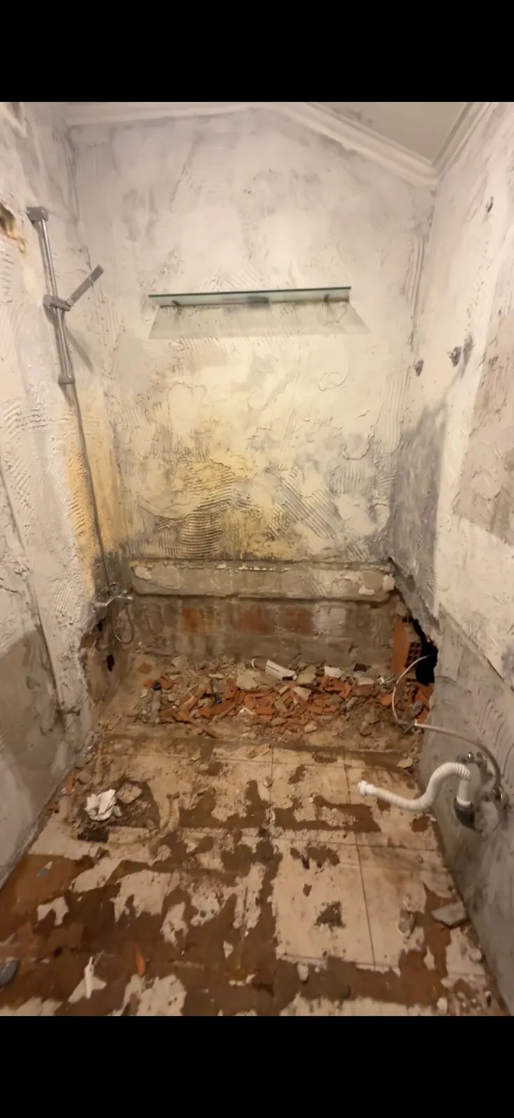 Casa de banho antes da obra: paredes em bruto e entulho no chão