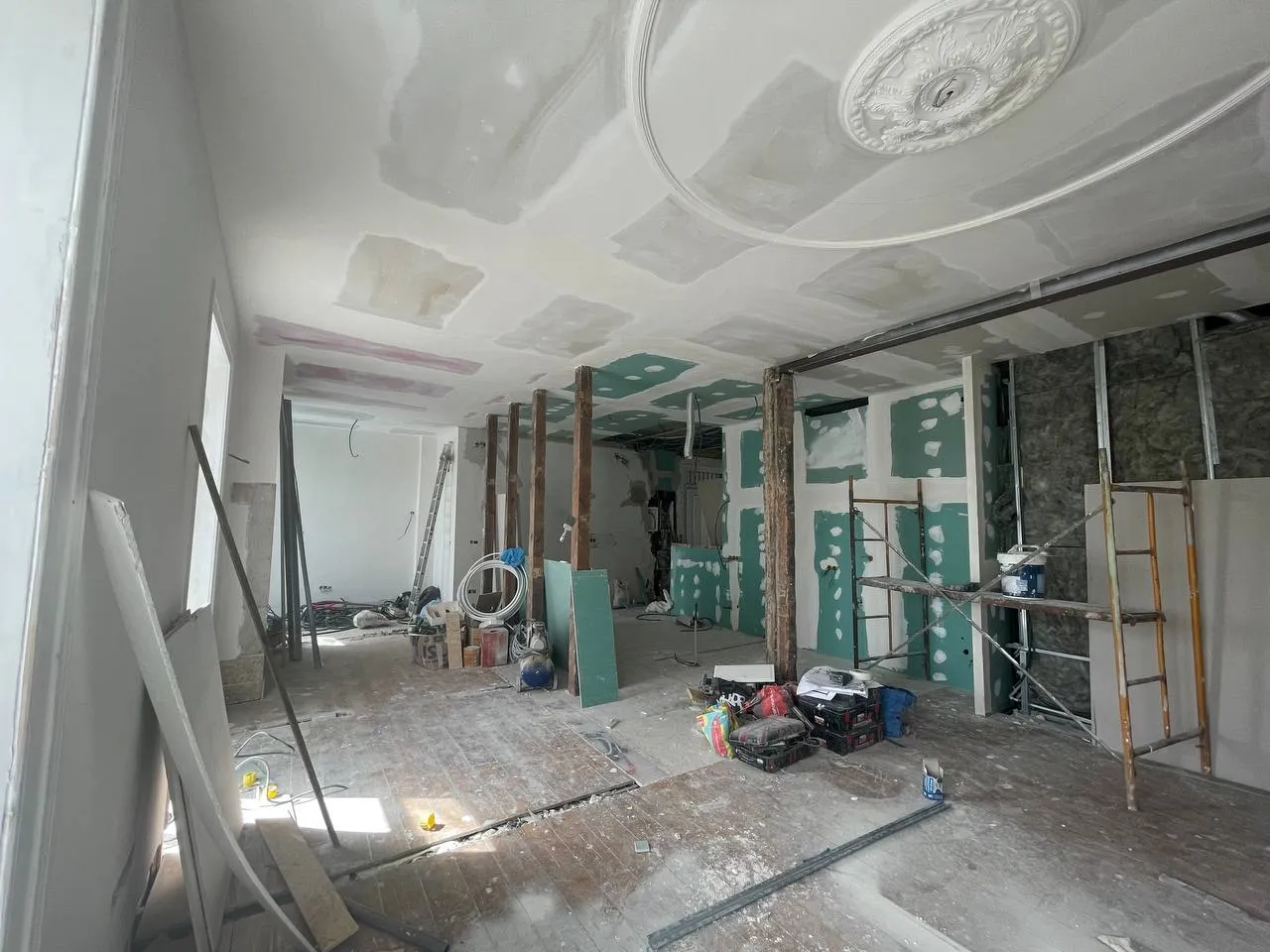 Zona da futura cozinha em obra, com gesso cartonado hidrófugo e prumos de madeira à vista