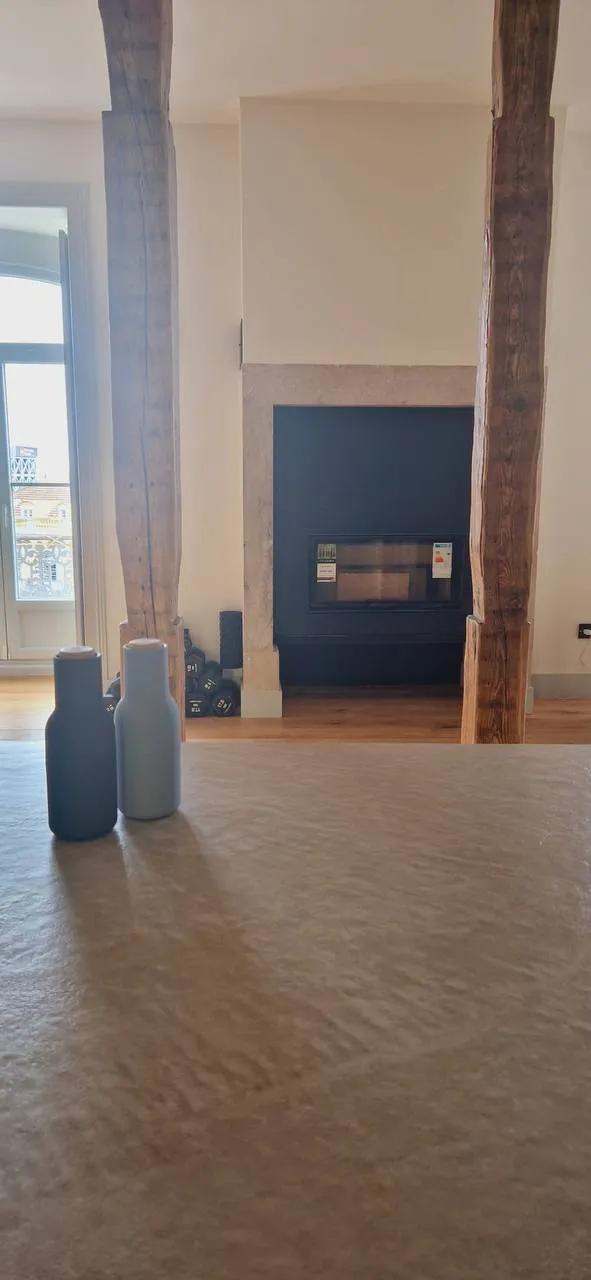 Sala concluída com porta lacada a azul escuro entre as colunas de madeira